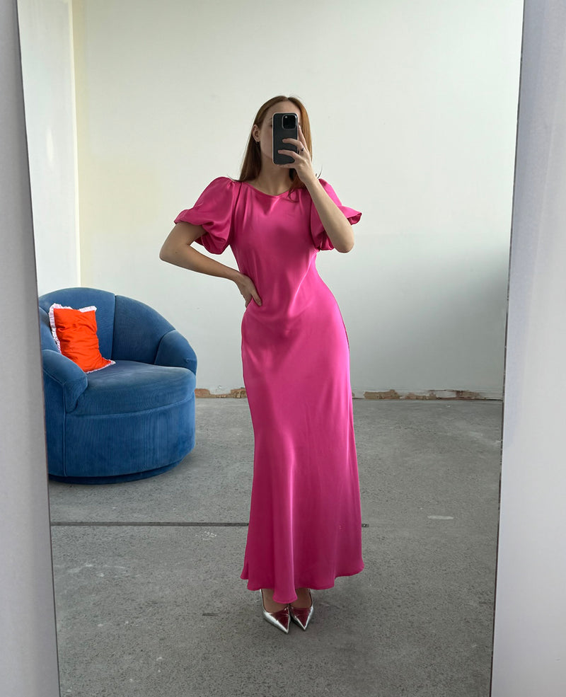 KENDALL SATIN DRESS HOT PINK | Bias cut satin midi dress with puff sleeves and a keyhole button closure at the back neck. The bias silhouette of this dress gently contours the body, while the satin...