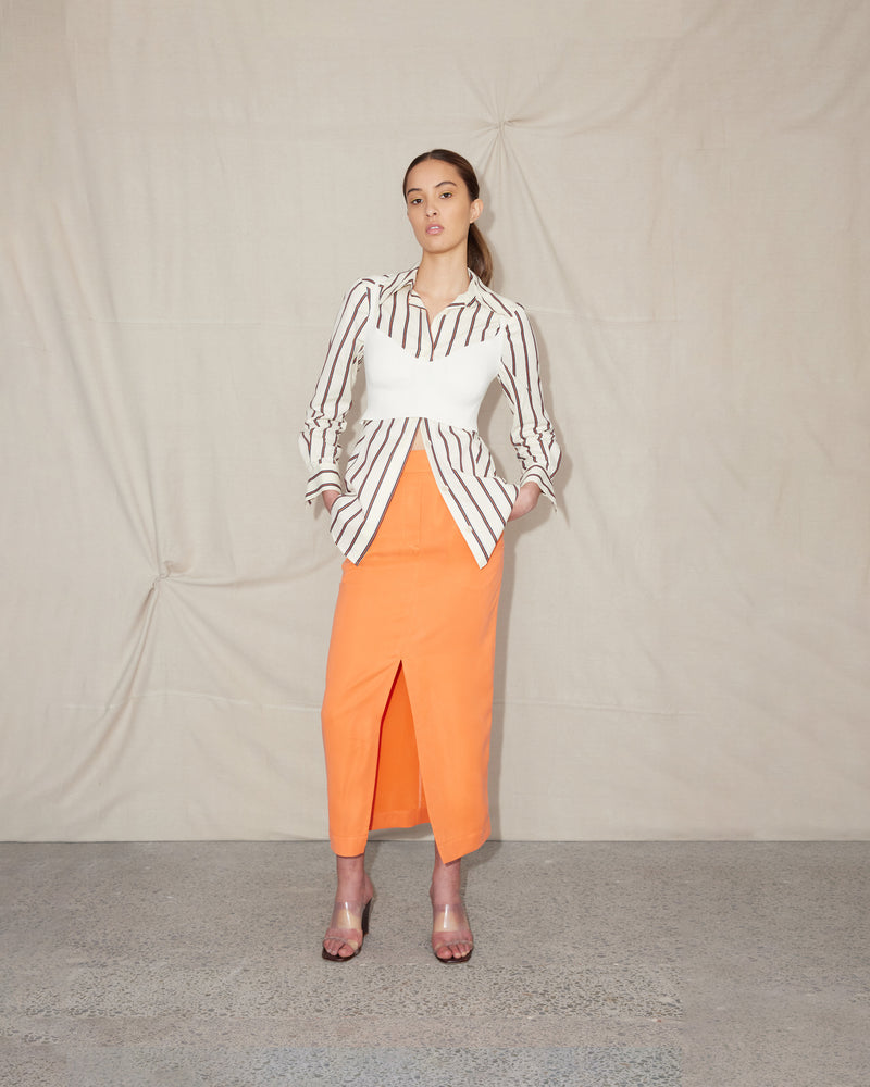 BEIGNET SKIRT ORANGEADE | Midi length pencil skirt designed in a playful orangeade cupro. With considered details such as front pockets, belt loops and an invisible back zip, the Beignet Skirt is made for...