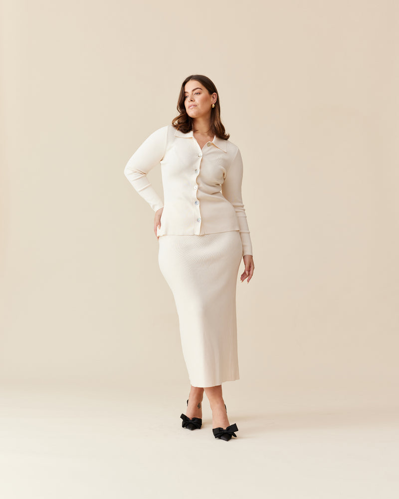 LOTTIE SKIRT CREAM | Stretch pencil skirt designed in a luxe viscose knit. Features a split for ease of movement and a ribbed waistband. This skirt pairs with the Lottie Cardigan.
