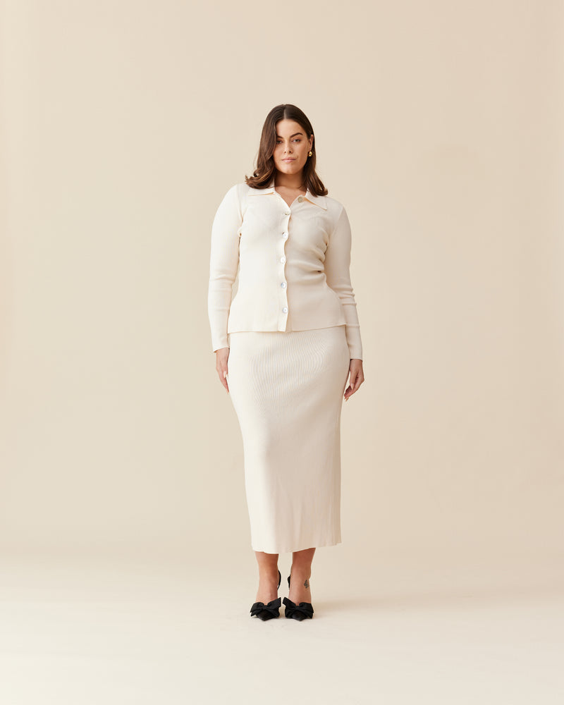 LOTTIE SKIRT CREAM | Stretch pencil skirt designed in a luxe viscose knit. Features a split for ease of movement and a ribbed waistband. This skirt pairs with the Lottie Cardigan.
