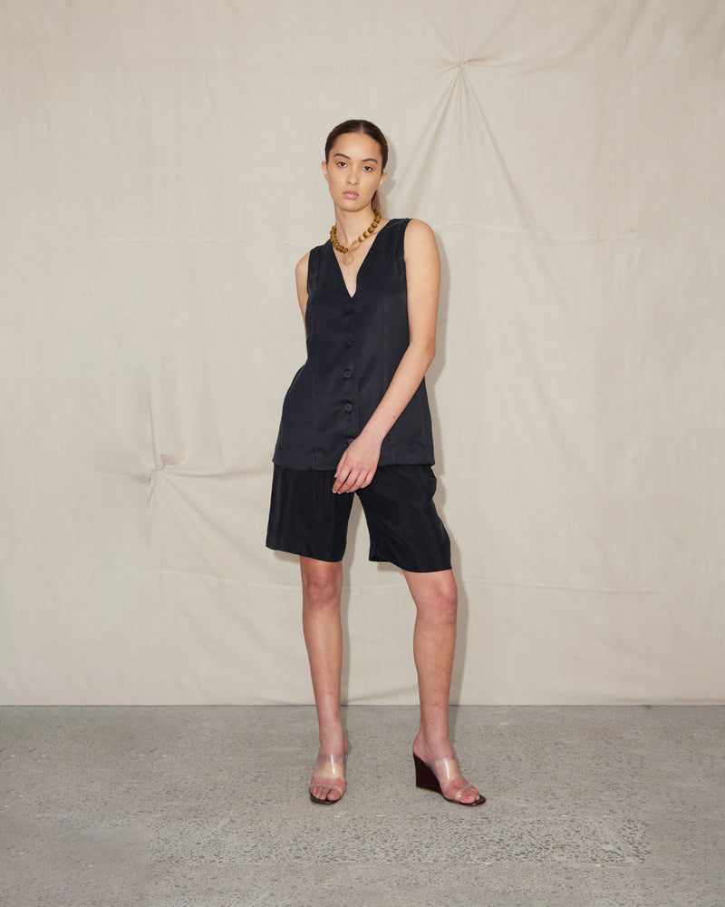 BEIGNET SHORT BLACK | Long-line relaxed short designed in a soft black cupro fabric. These shorts are designed to sit mid-waist, with a faux fly front, belt loops and back zip closure, which gives...