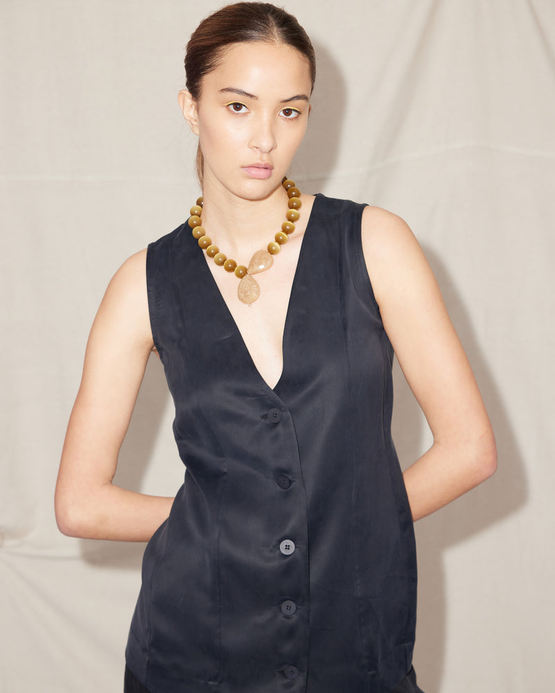 THELMA VEST BLACK | Long-line vest designed in a soft black cupro. Features panelling, a waist tie at the back and black buttons for a sleek look. This piece is versatile in that it...