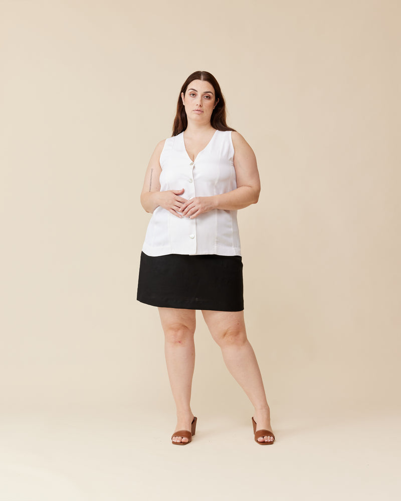 THELMA VEST WHITE | Long-line vest designed in a soft white cupro. Features paneling, a waist tie at the back and white buttons for a sleek look. This piece is versatile in that it can be...