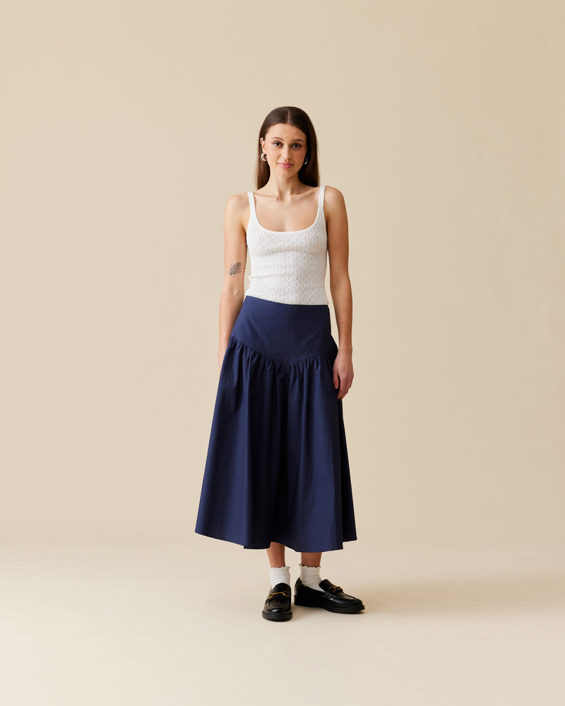 NONI SKIRT NAVY | Floaty basque style midi skirt imagined in a navy cotton fabric. This skirt features a bodice-style waistline, that falls to a full, wide skirt and has a dipped front hemline....