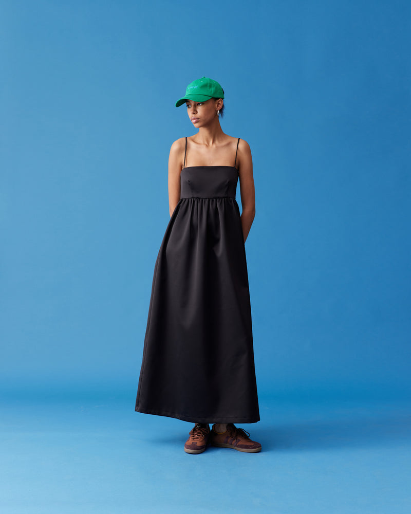 CHER MAXI DRESS BLACK | A-line maxi dress designed in a luxe heavy-weight satin. This dress has a square banded bust with darts for shaping, and falls to a softly gathered skirt with pockets. Simple...