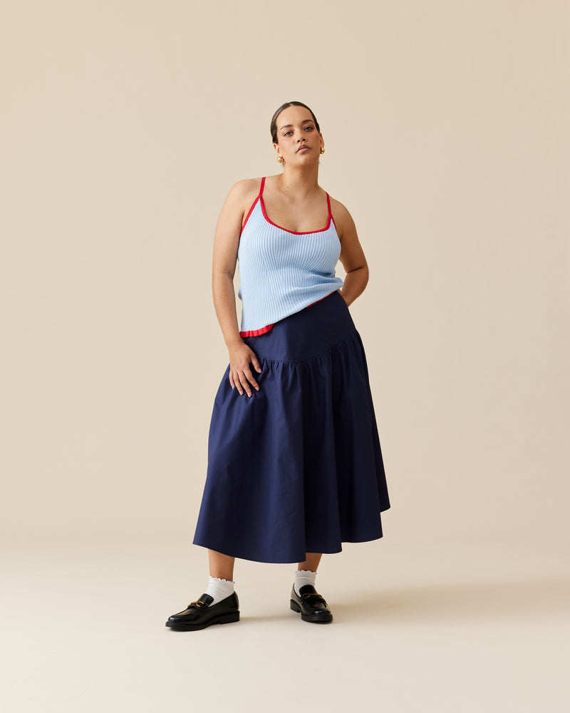 RINA TANK BLUE CHERRY | Ribbed knitted tank top designed in a contrasting blue and cherry colour way. This staple tank can be worn many ways by adjusting the straps, giving you 4 options in...