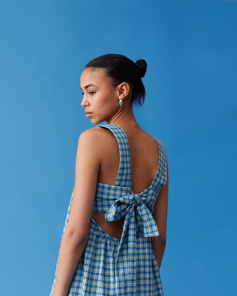 MARGIE TIE MINI DRESS BLUE YELLOW CHECK | Cotton mini dress with puff sleeves and with a square band bust. The skirt falls into an A-line shape with an exposed back and bow tie closure.
