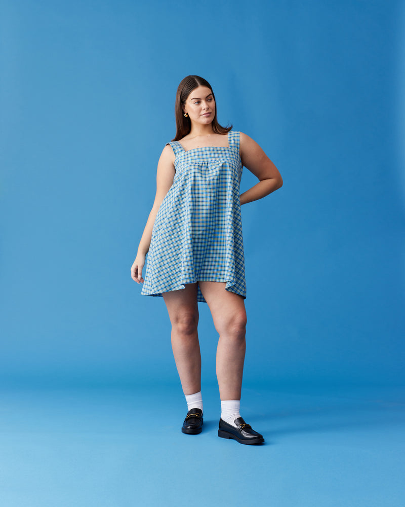 MARGIE TIE MINI DRESS BLUE YELLOW CHECK | Cotton mini dress with puff sleeves and with a square band bust. The skirt falls into an A-line shape with an exposed back and bow tie closure.
