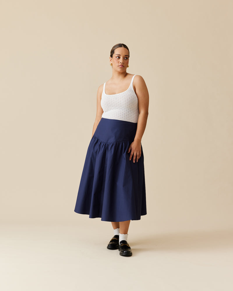 NONI SKIRT NAVY | Floaty basque style midi skirt imagined in a navy cotton fabric. This skirt features a bodice-style waistline, that falls to a full, wide skirt and has a dipped front hemline....