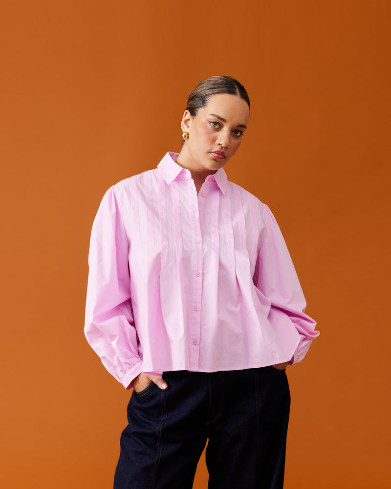 NAOMI SHIRT PINK | A classic pink shirt that is elevated by the front box pleats. This shirt also features a 'balloon' sleeve, that looks great layered under vests and tops.
