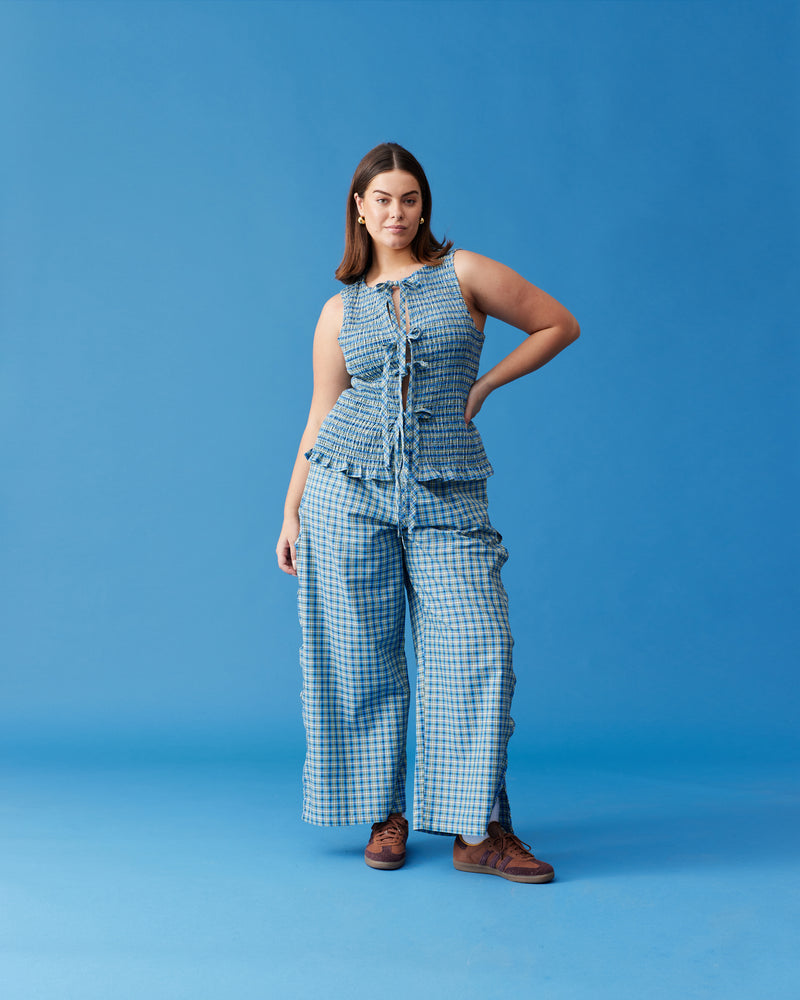 TRULLI PANT BLUE YELLOW CHECK | Mid-waist cotton pant designed in a blue and yellow checked cotton. Features wave cut-outs down the outside of the legs, making these a fun piece for your wardrobe.
