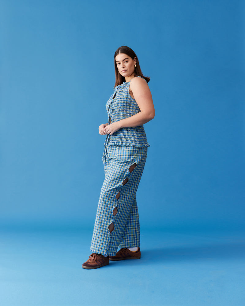 TRULLI PANT BLUE YELLOW CHECK | Mid-waist cotton pant designed in a blue and yellow checked cotton. Features wave cut-outs down the outside of the legs, making these a fun piece for your wardrobe.
