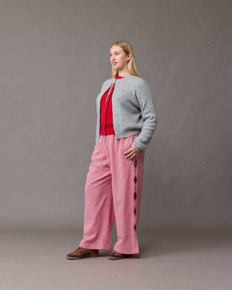 TRULLI PANT RED GINGHAM | Mid-waist cotton pant designed in a red gingham. Features wave cut-outs down the outside of the legs, making these a fun summer piece.