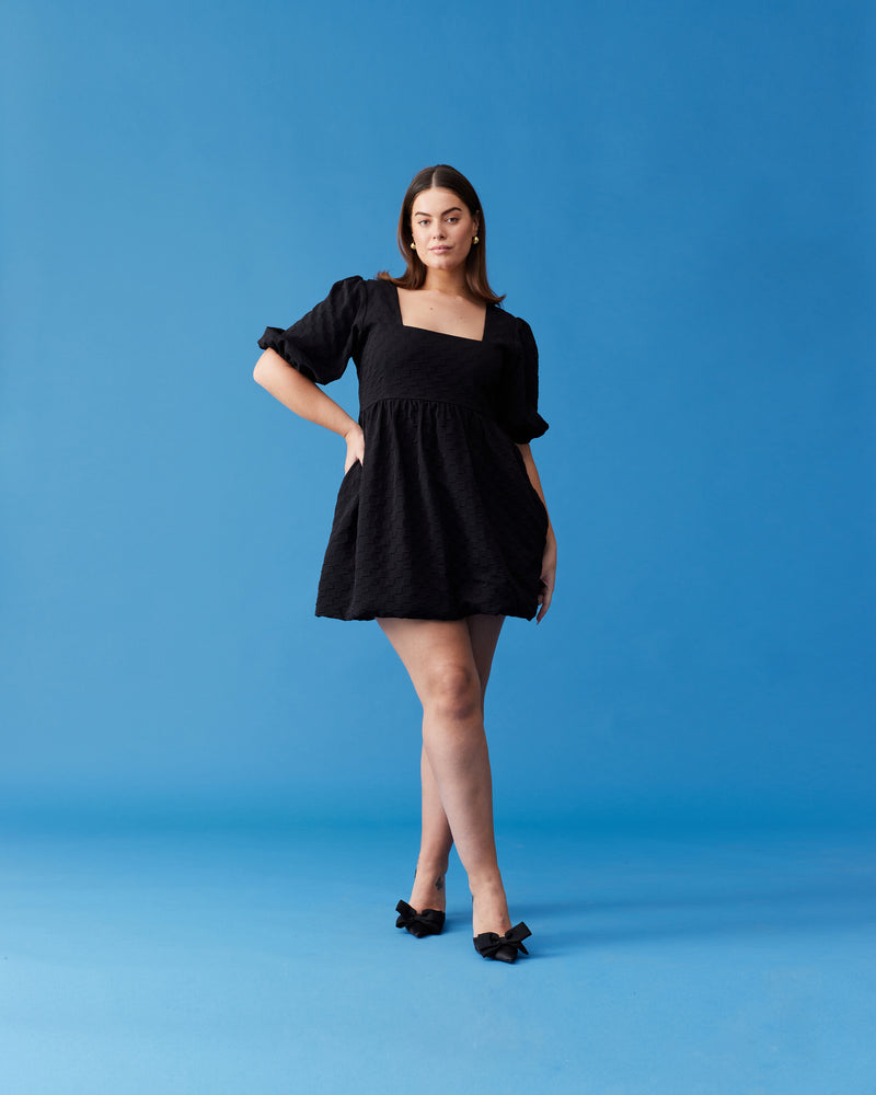 TULIP MINI DRESS BLACK | Short sleeve mini dress designed in a textured burnout checkered fabric. Features a babydoll-style bodice that falls to a floaty A-line skirt.